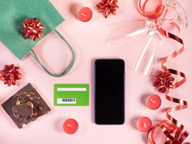 İnternetten sevgililer günü alışverişi. Hediye, mumlar, pembe arka planda gözlük.