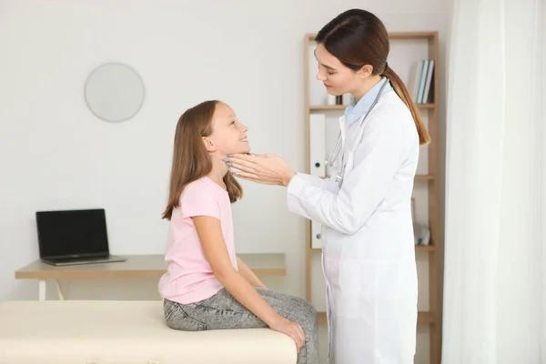 Молодая девушка врач педиатр делает осмотр маленькой девочки — стоковое фото