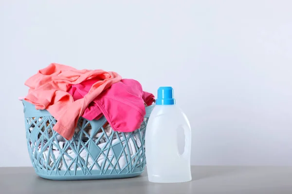 Laundry detergent bottles and clothes on the table. Household chemicals