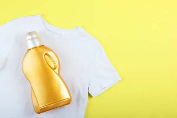Botellas de detergente de lavandería y ropa en la mesa. Productos químicos domésticos — Foto de Stock