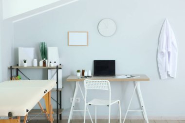 Kanepesi ve çalışma masası olan bir doktor ofisi. Doktorların işyeri 