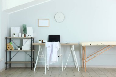 Kanepesi ve çalışma masası olan bir doktor ofisi. Doktorların işyeri 