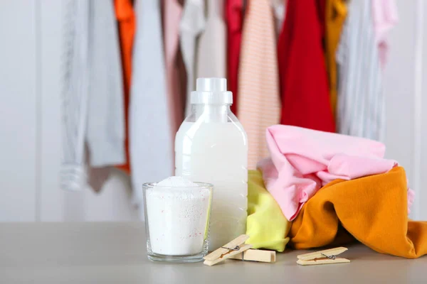 Butelki po detergentach i ubrania na stole. Chemikalia dla gospodarstw domowych — Zdjęcie stockowe