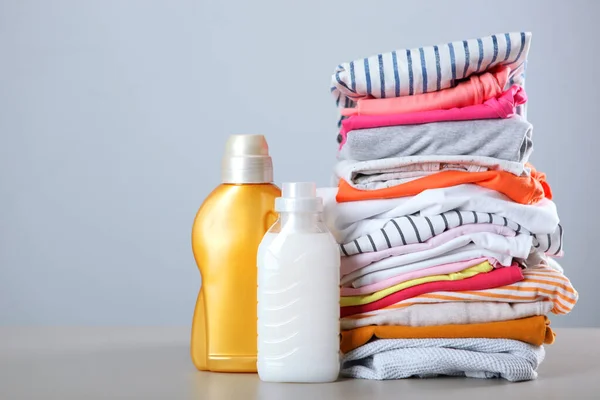 Laundry detergent bottles and clothes on the table. Household chemicals