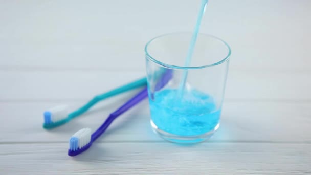 Mouthwash on the table in a glass. Oral care — Stock Video