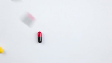 Turuncu arka planda farklı renk ve boyutlarda haplar..