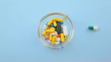 Turuncu arka planda farklı renk ve boyutlarda haplar..