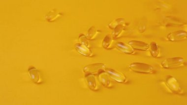 Turuncu arka planda Omega 3 kapsülleri. Yiyecek takviyeleri, vitaminler..