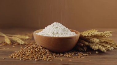Tahta bir masada buğday unu, buğday taneleri ve dikenler. Ekin unu. 