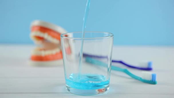 Mondwater op de tafel in een glas. Orale zorg — Stockvideo