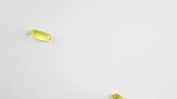 โอเมก้า 3 แคปซูลบนพื้นหลังสีขาว อาหารเสริม วิตามิน . — วีดีโอสต็อก