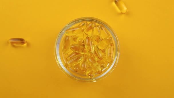 Omega 3 tobolky na oranžovém pozadí. Doplňky stravy, vitamíny. — Stock video