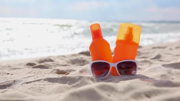 Écrans solaires sur la plage près de la mer gros plan — Video