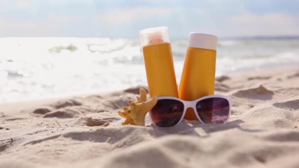 Écrans solaires sur la plage près de la mer gros plan — Video