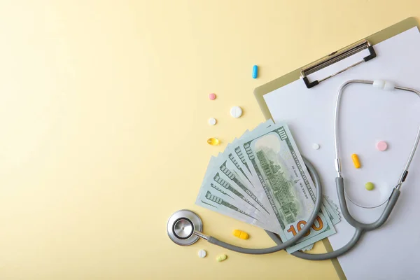Медичний стетоскоп і гроші на кольоровому фоні вид зверху крупним планом — стокове фото