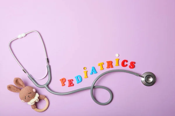 Gyermekgyógyászati koncepció. sztetoszkóp és játék könnyű háttérrel — Stock Fotó
