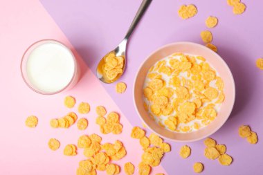 Kahvaltıda sütlü gevrek mısır gevrekleri. Renkli bir arka planda. Yakın plan..