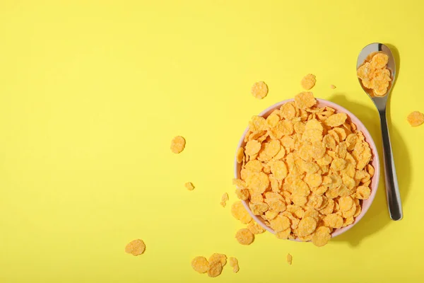 Delicious cornflakes in a plate against colored background. — Stock Photo, Image