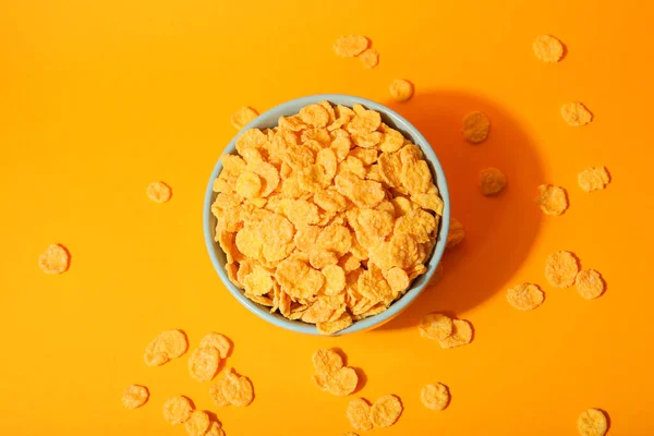 Delicious cornflakes in a plate against colored background. — Stock Photo, Image
