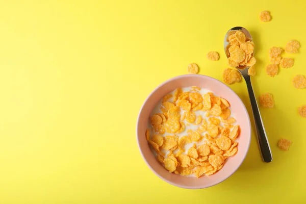 Хрусткі кукурудзяні пластівці з молоком на сніданок на кольоровому фоні крупним планом . — стокове фото