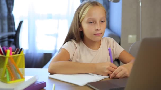 Iskoláslány tanulmányok online egy modern laptop. Házi feladat — Stock videók