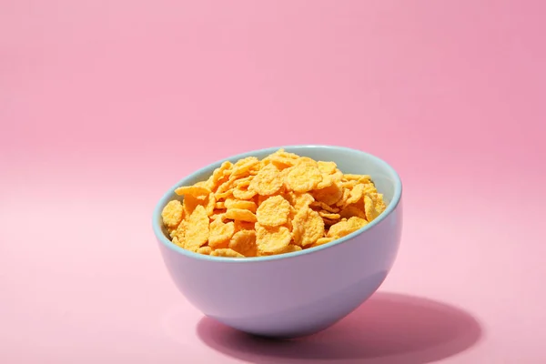 Delicious cornflakes in a plate against colored background. — Stock Photo, Image