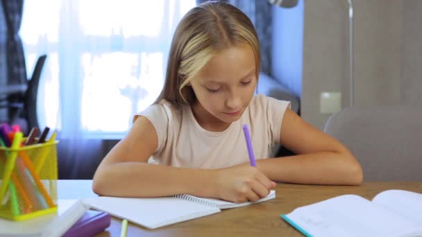 Écolière fait ses devoirs dans un intérieur de maison moderne. — Video