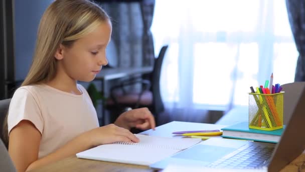 Colegiala estudia en línea utilizando un ordenador portátil moderno. Tareas — Vídeos de Stock