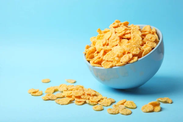 Delicious cornflakes in a plate against colored background. — Stock Photo, Image