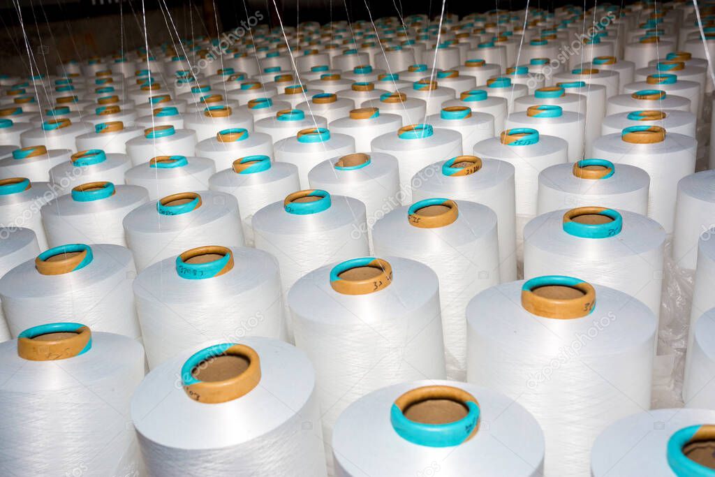 A pattern of white cotton spools with threads. An old system manual loom machine for clothing.