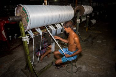 Bangladeş 05 Ağustos 2019: İplik fabrikası işçileri Bangladeş, Narsingdi 'de yeni yapılan beyaz ipliği tekrar kontrol ediyorlar