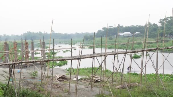 バングラデシュ2021年5月2日 2つの村を結ぶ大きな運河の上に原始的な竹の橋が建設されましたが それは西かすかなプール モリーチャ橋 ムンシガンジ ダッカであまりにも危険な歩道です — ストック動画