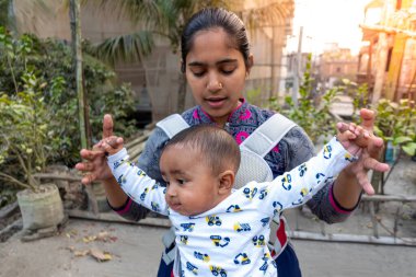 Annem öğleden sonra sevimli tombul oğluyla çatıda oynuyordur. Anne-bebek bakımı ve motor geliştirme kavramı.