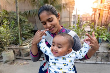 Annem öğleden sonra sevimli tombul oğluyla çatıda oynuyordur. Anne-bebek bakımı ve motor geliştirme kavramı.