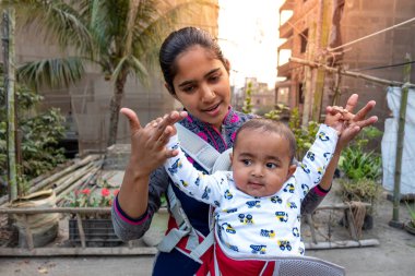 Annem öğleden sonra sevimli tombul oğluyla çatıda oynuyordur. Anne-bebek bakımı ve motor geliştirme kavramı.