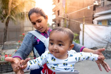 Annem öğleden sonra sevimli tombul oğluyla çatıda oynuyordur. Anne-bebek bakımı ve motor geliştirme kavramı.