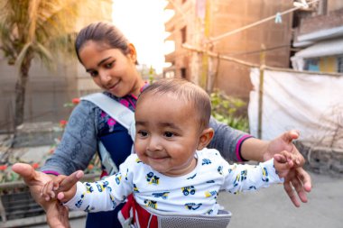 Annem öğleden sonra sevimli tombul oğluyla çatıda oynuyordur. Anne-bebek bakımı ve motor geliştirme kavramı.