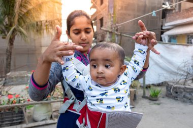 Annem öğleden sonra sevimli tombul oğluyla çatıda oynuyordur. Anne-bebek bakımı ve motor geliştirme kavramı.