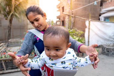 Annem öğleden sonra sevimli tombul oğluyla çatıda oynuyordur. Anne-bebek bakımı ve motor geliştirme kavramı.
