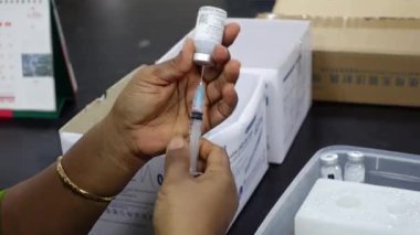 Bir sağlık çalışanı Bangladeş, Dhaka 'daki Matuail Çocuk ve Anne Sağlığı Enstitüsü' nde (ICMH) bir şişe Moderna Covid-19 aşısı kullanıyor. 19 Temmuz 2021