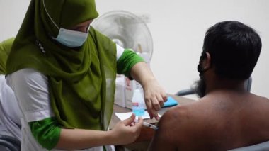 Sağlık çalışanı Bangladeş 'in Dhaka kentindeki Matuail Çocuk ve Anne Sağlığı Enstitüsü' nde (ICMH) bir kişinin vücuduna hükümet tarafından sağlanan Covid-19 aşısını enjekte ediyor. 16 Ağustos 2021.
