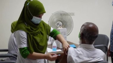 Sağlık çalışanı Bangladeş 'in Dhaka kentindeki Matuail Çocuk ve Anne Sağlığı Enstitüsü' nde (ICMH) bir kişinin vücuduna hükümet tarafından sağlanan Covid-19 aşısını enjekte ediyor. 16 Ağustos 2021.