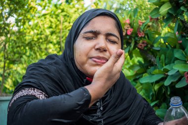 Sıcak bir günde bir kadın yüzüne soğuk su sıçratır. Siyahlar giymiş Müslüman bir kadın suyla abdest alıyor. Yüzü suyla temizleme kavramı.