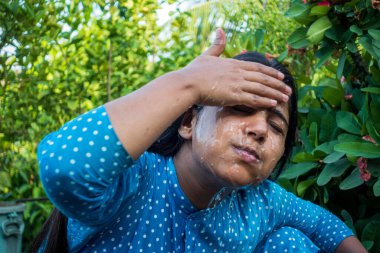 Sıcak bir günde bir kadın yüzüne soğuk su sıçratır. Yüzünü suyla temizleyen genç bir kızın yakın görüntüsü. Mutlu güzel kız yüzünü saf suyla yıkar..