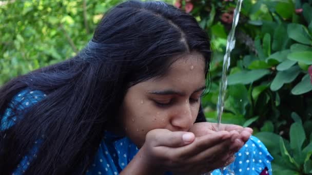 在一个炎热的日子里 一个亚洲漂亮的小女孩正手握着水喝水 一个年轻女孩的特写是喝水 慢动作视频 — 图库视频影像