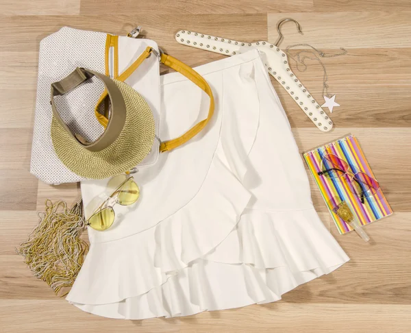 White skirt with ruffles and accessories arranged on the floor. — Stock Photo, Image