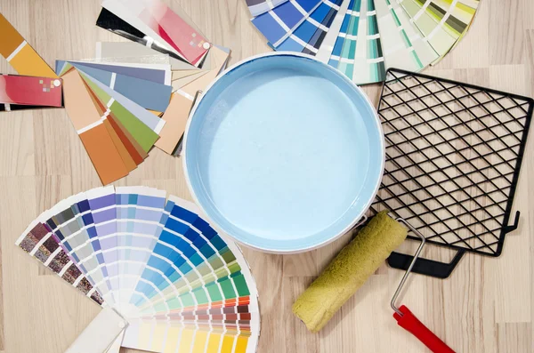 Samples with different shades of blue and can of blue paint with paint roller and accessories. — Stock Photo, Image