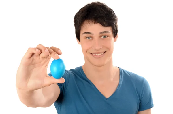 Gelukkig jonge man houden omhoog een blauwe easter egg. — Stockfoto