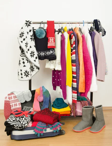 Packing the suitcase for winter vacation. Wardrobe with clothes nicely arranged and a full luggage. — Stock Photo, Image