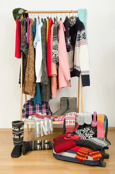 Packing the suitcase for winter vacation. Wardrobe with clothes nicely arranged and a full luggage. — Stock Photo, Image